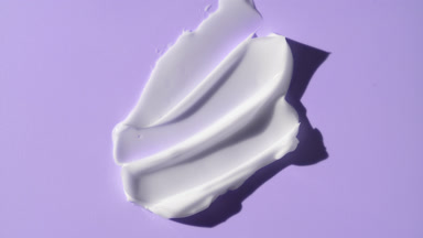 Lightening cream smears on purple background with moving light