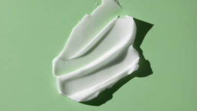 Lightening cream smears on green background with moving lighting