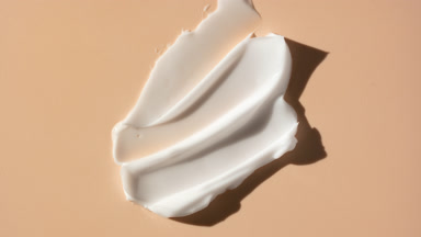 Lightening cream smears on beige background with moving lighting