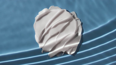 White cream smears on blue background under rippling water