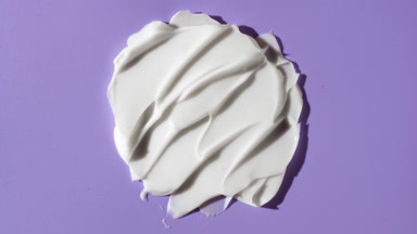 White day cream smears on purple background with moving light