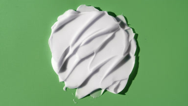White day cream smears on green background with moving light