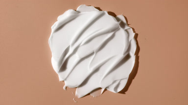 White day cream smears on beige background with moving light