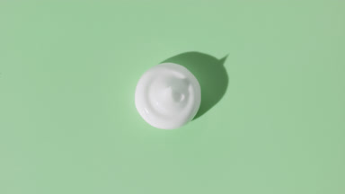 White cream drop appears from shadow turning on green background