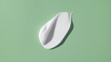 Whitening cream smear on green background with moving light
