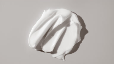 Lightening cream smears appear from shadow on white background