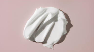 White cream smears appear from shadow on pale pink background