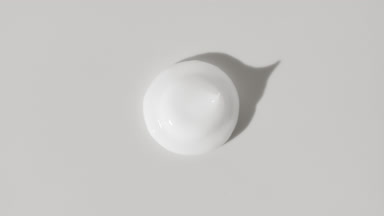 White eye cream drop appears from the shadow on white background