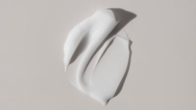 Face cream smears appear from the shadow on white background