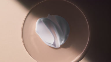 Cream smears on glass appear from shadow on beige background