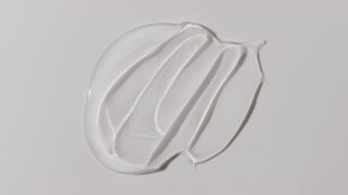 Colorless face gel smears appear from shadow on white background