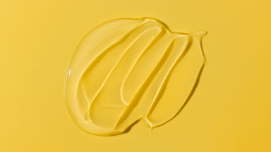 Macro of face gel smears appear from shadow on yellow background