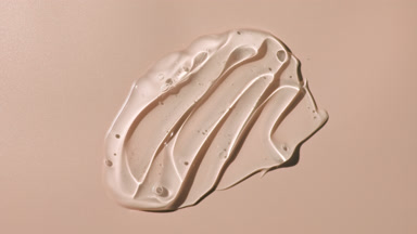 Colorless gel smears appear from the shadow on beige background