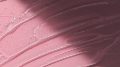 Colorless gel texture on pale pink background appear from shadow
