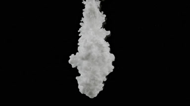 Shot of white ink is being injected in water on black background