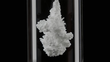 White ink injected in test tube with water on black background