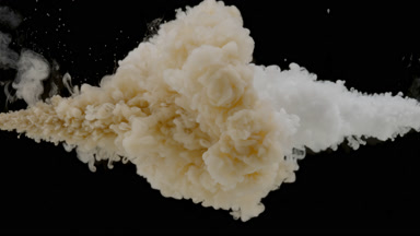 Beige and white inks injected in water on black background
