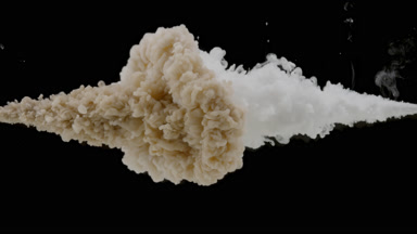 Brown and white ink injected in water mixing on black background