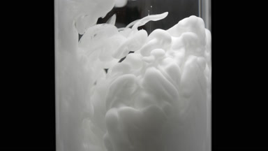 Macro of white ink injected in test tube with water fills it