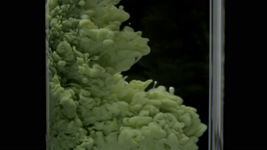 Macro of green ink injected in test tube with water fills it