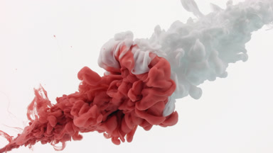 Red and white inks being injected in water on white background