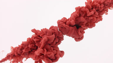 Red ink being injected in water from corners on white background