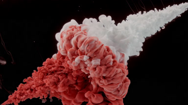 Red and white inks being injected in water on black background