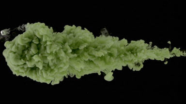 Light green ink is being injected in water on black background