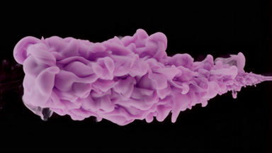 Macro of purple ink being injected in water on black background