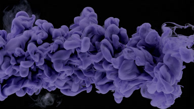 Macro of violet ink being injected in water on black background