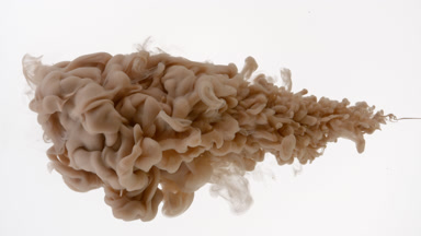 Macro of brown ink being injected in water on white background