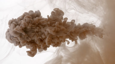 Macro of brown ink injected in cloudy water on white background
