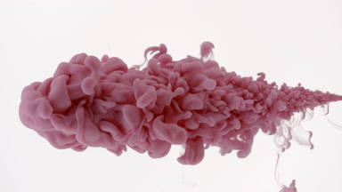 Macro of pink ink being injected in water on white background