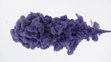 Macro of violet ink being injected in water on white background