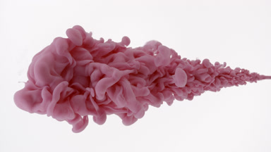 Macro shot of pink ink is being injected in water flows back
