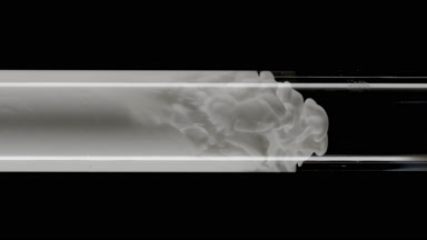 Grey ink flows inside test tube with water on black background