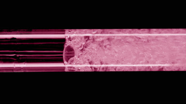 Macro of water is being poured into pink test tube filling it