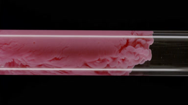 Pink ink flows inside test tube with water on black background