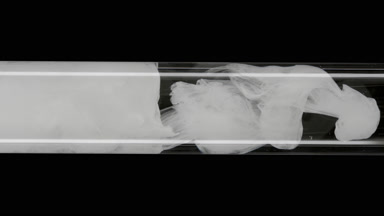 White ink flows inside test tube with water on black background