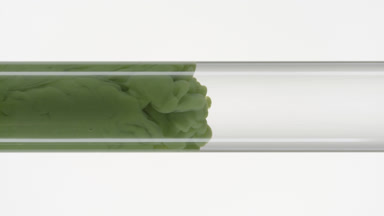 Green ink flows inside test tube with water on white background