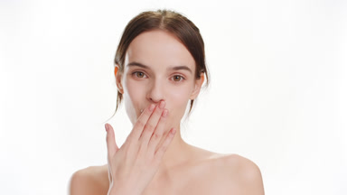 Pretty young Caucasian woman blows a kiss on white background