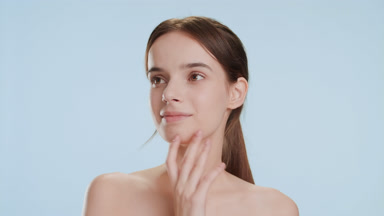 Pretty woman strokes jawline and chin turning head out of camera