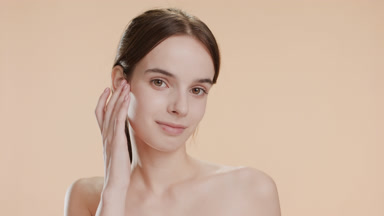 Young woman strokes jawline and chin turning head out of camera