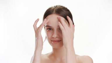 Cute woman strokes her forehead smiling wide on white background