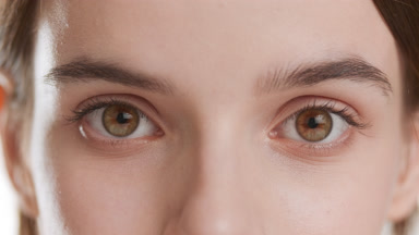 Extreme close-up shot of good-looking woman opens her hazel eyes