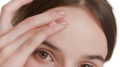Good-looking woman strokes her forehead on white background