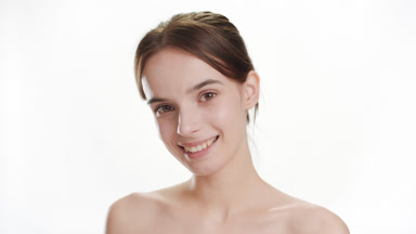 Cute Caucasian woman opens eyes and looks at camera smiling wide