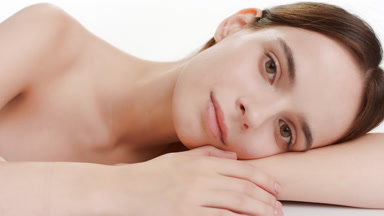 Beautiful young Caucasian woman puts head on bent arm smiling
