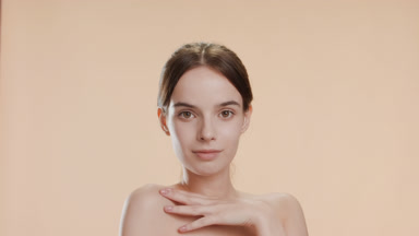 Beautiful slim woman strokes her shoulder turning body to camera