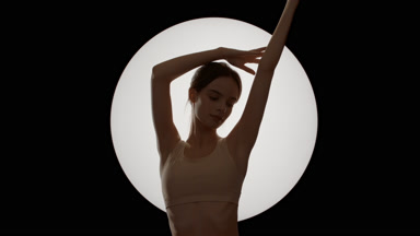 Gorgeous Caucasian woman in beige top strokes her arm above head